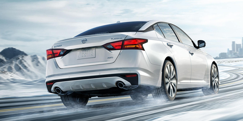 Nissan Altima driving on a snowy mountain road