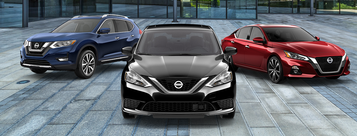 Three Nissan cars parked on a tiled surface