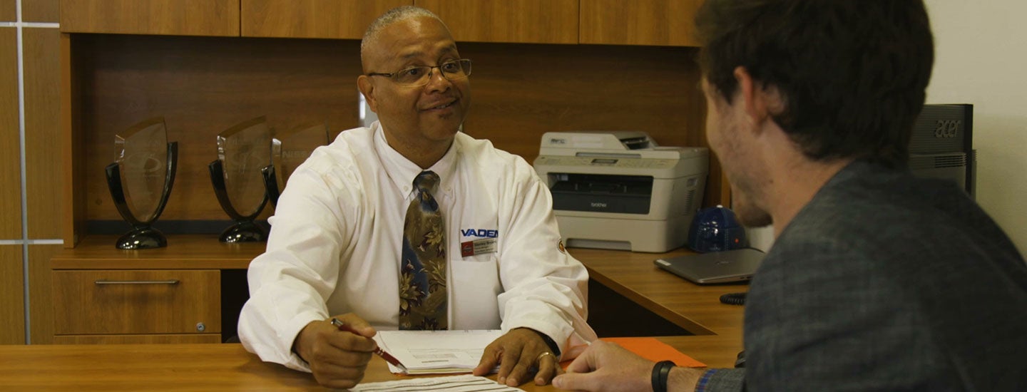 Two men discussing documents in a professional office setting